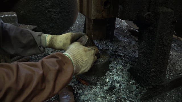 Worker handling metal in a factory
