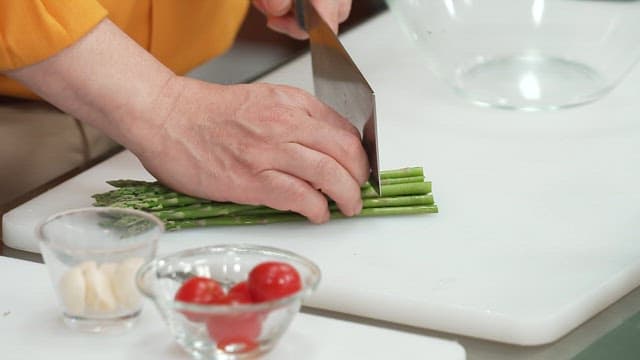 Cutting Fresh Asparagus on a Cutting Board