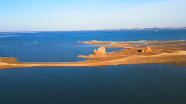 Rocky coastline extending into the sea on a sunny day