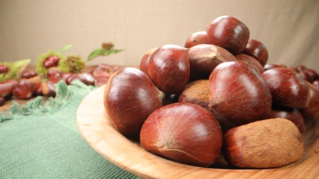 Wooden bowl filled with fresh chestnuts