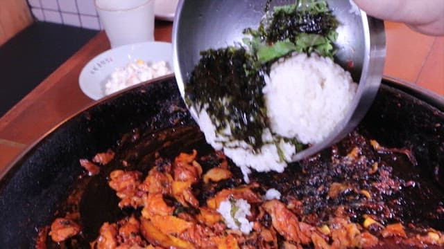 Fried rice ingredients poured into spicy stir-fried chicken