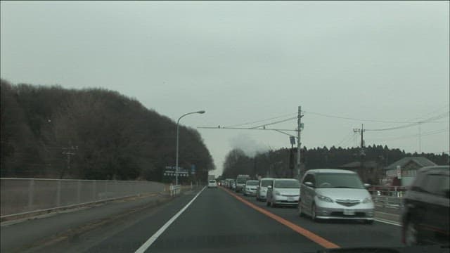 Narrow road with lots of cars on a cloudy day