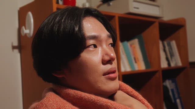 Person listening to a story indoors wrapped in a blanket