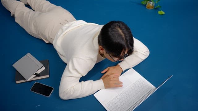 Man laying on the floor working on a laptop