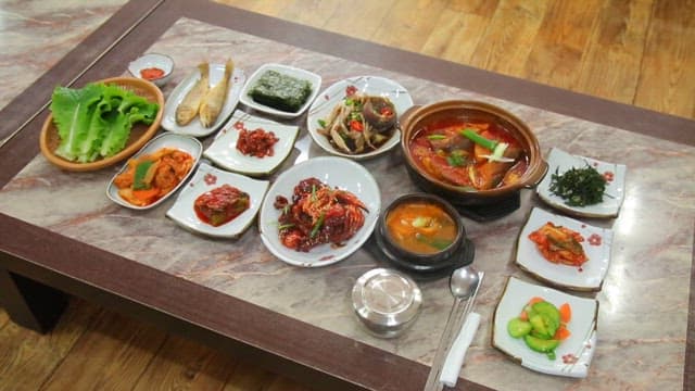 Variety of Korean dishes on a table such as marinated crab and stew