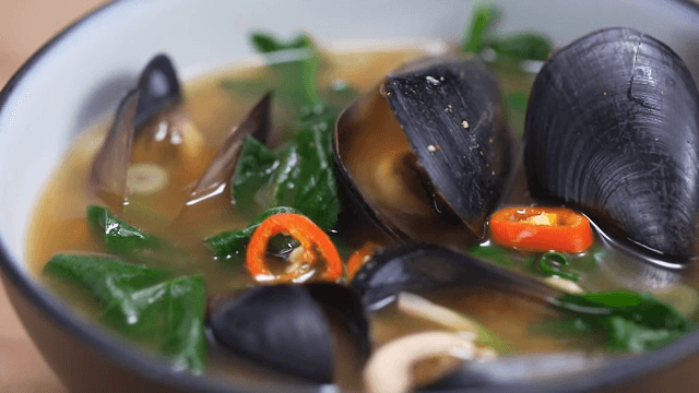 Fresh spicy seafood noodle soup in a bowl on a table