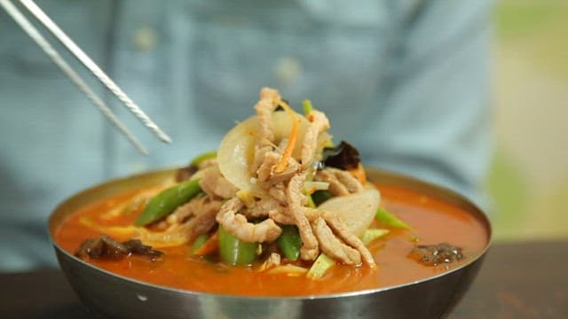 Stirring spicy jjambbong with chopsticks with lots of meat