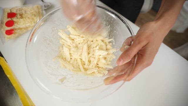 Mixing Sliced ​​Potatoes in a Glass Bowl with Flour