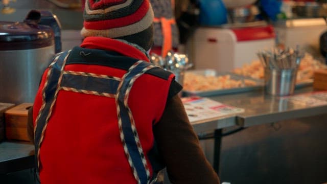 Vendor preparing food at a market stall