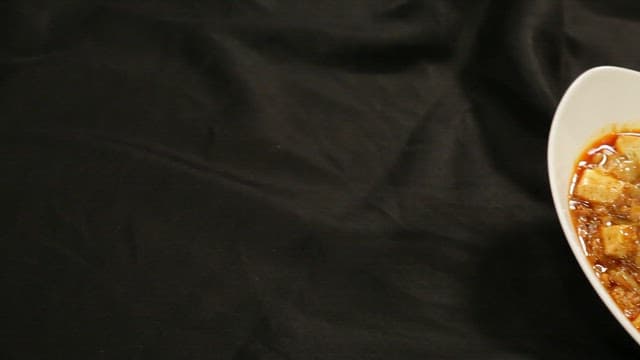 Bowl of mapo tofu on a black cloth