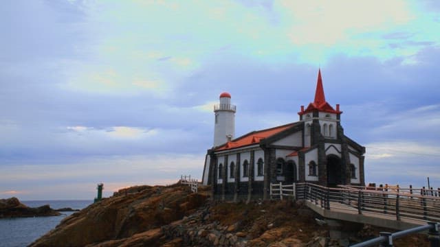Seaside with a cathedral set with tourists in the evening