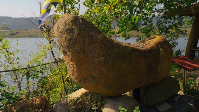 Rock tower surrounded by trees and greenery