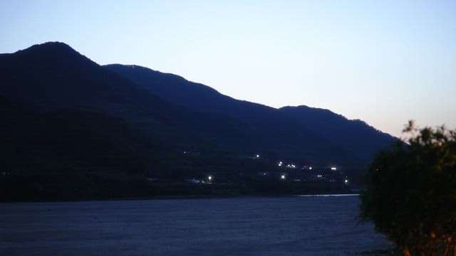 Evening twilight over a scenic mountain landscape with lights
