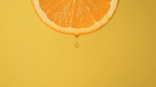 Scene with juice dripping from an orange on a yellow background