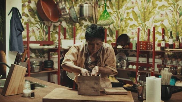 Man taking items out of a wooden box in a rustic kitchen