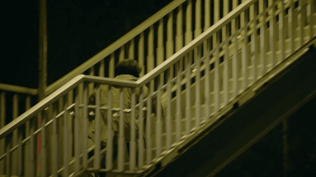 Woman running along the overpass stairs at night