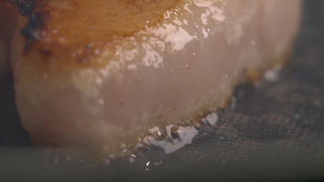 Pork belly sizzling on a hot pan