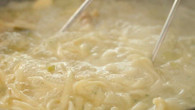 Chewy noodles in boiling chicken soup