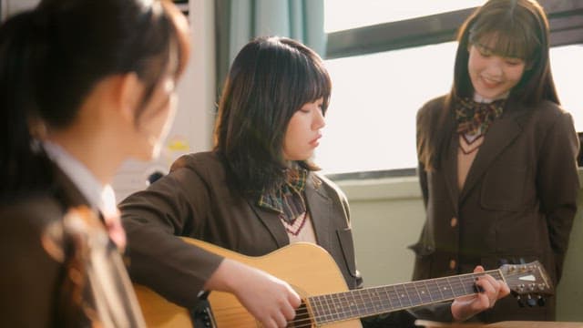 Student playing guitar in a classroom