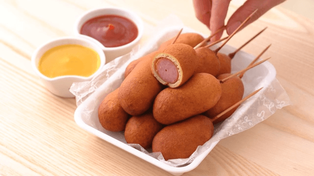 Scene of picking up a hot dog with cross section visible