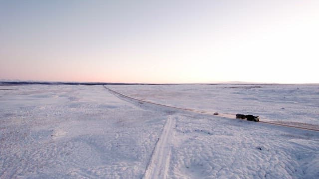 Car driving through a snowy landscape