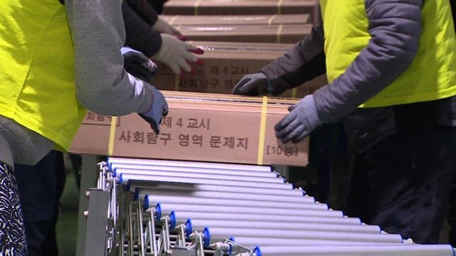 People Moving Boxes of Packed CSAT Question Papers