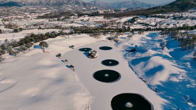Snow-covered Landscape with Circular Ponds