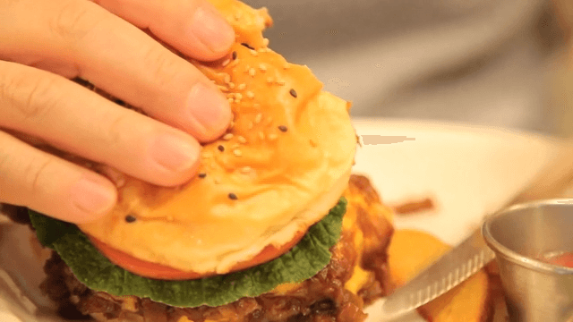 Eating a hamburger with a thick patty