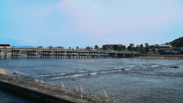 Historic wooden bridge over a wide river under a clear blue sky