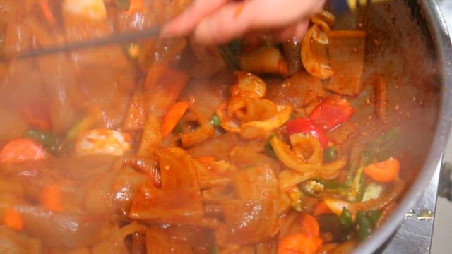 Cooking spicy stir-fried pork rinds in a pan