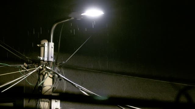 Rainy night street with wet streetlamp illuminating