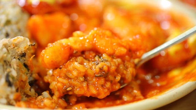 Spoonful of rice mixed with tteokbokki sauce