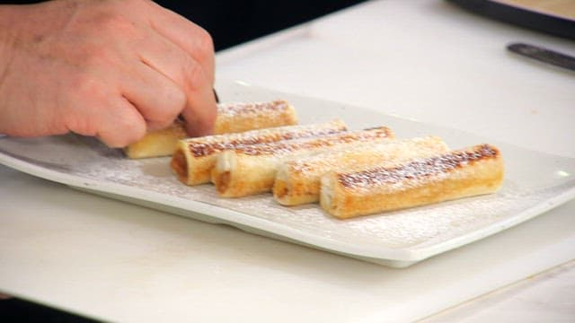 Chef preparing and arranges pastry rolls on plate