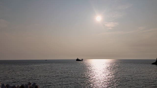 Ship sailing under the sun