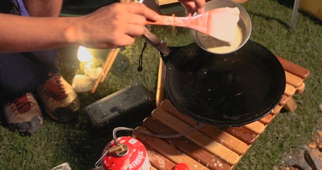 Preparing Vegetable Pancakes Outdoors at Night during Camping