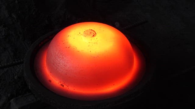 Red-hot cast-iron cauldron in a foundry