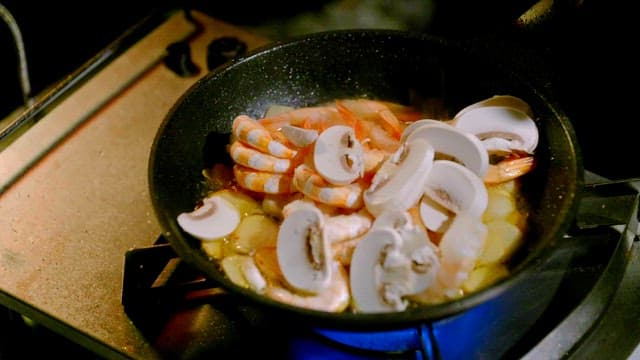 Shrimp and mushrooms cooking in a pan