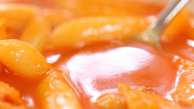 Spicy tteokbokki with sauce in a spoon