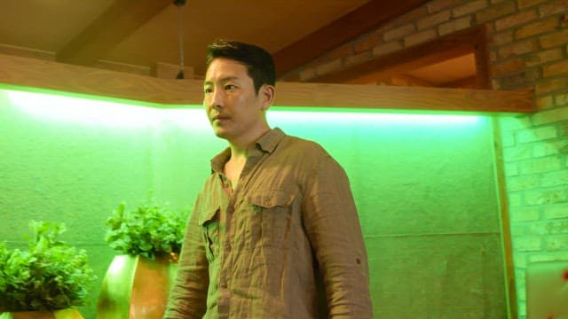 Man looking around in green light indoors