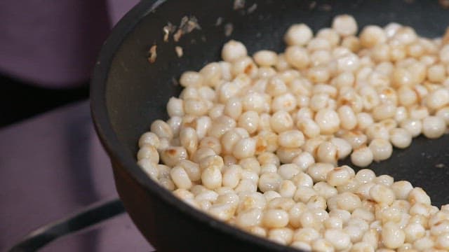 Adding Sugar to Corn in a Frying Pan