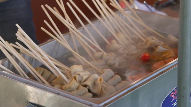 Skewered fishcakes being cooked in hot broth