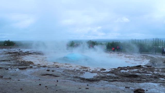 Tourists Watching an Erupting Geyser
