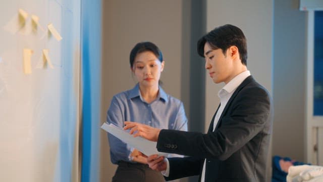 Two colleagues discussing at a whiteboard