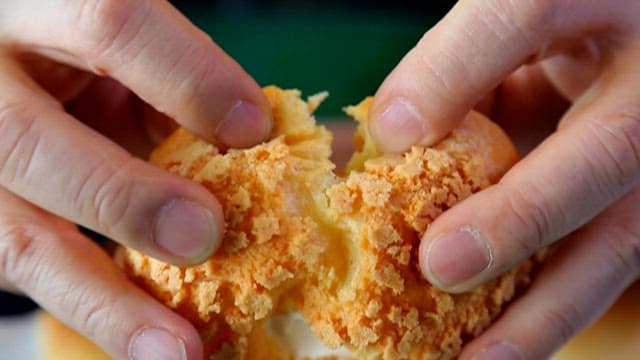 Hands Tearing Apart a Creamy Pastry