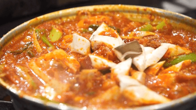 Spicy braised pork ribs boiling on a gas stove