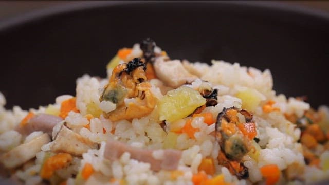 Mixing mussel rice with seasoning sauce