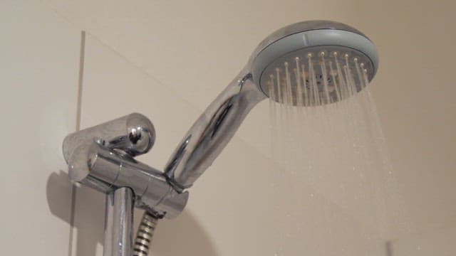Water pouring from the showerhead in the bathroom