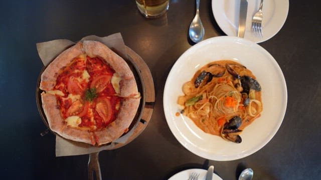 Delicious pizza and seafood pasta served on a restaurant table