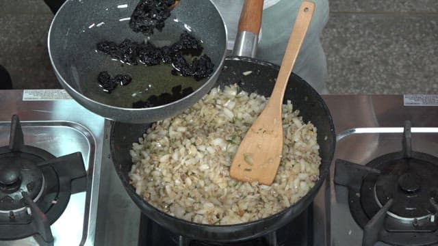Adding Chunjang into a Frying Pan with Fried Onions and Meat