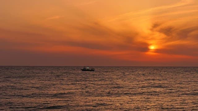 Serene sunset over the ocean with a boat